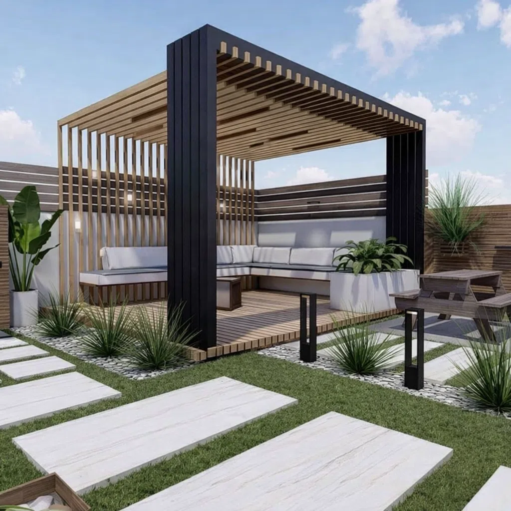 جلسة خارجية خشبية مع هيكل معدني أسود وسقف شرائح، تضم مقاعد زاوية فوق منصة WPC، محاطة بعشب طبيعي وممرات حجرية