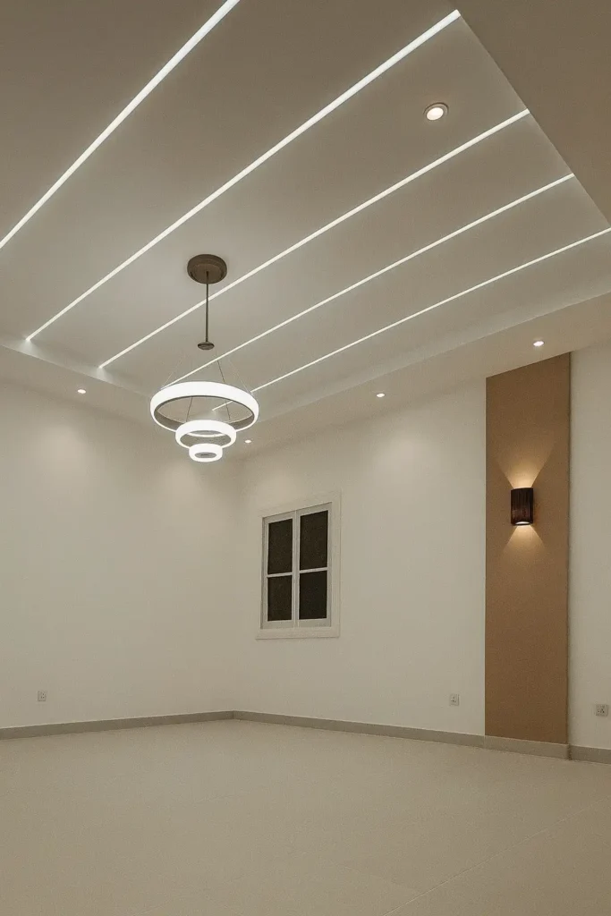 تصميم سقف جبس بورد بإضاءة خطية أنيقة وثريا معلقة في غرفة واسعة