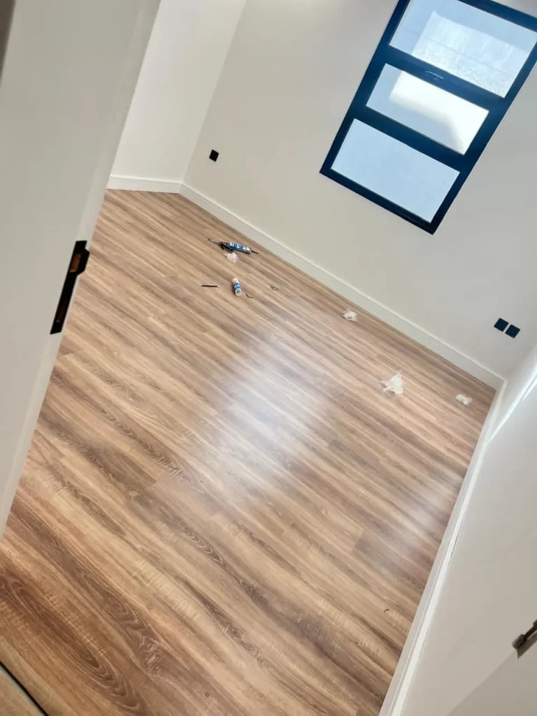 باركيه بنية وجدار ابيض ونافذة