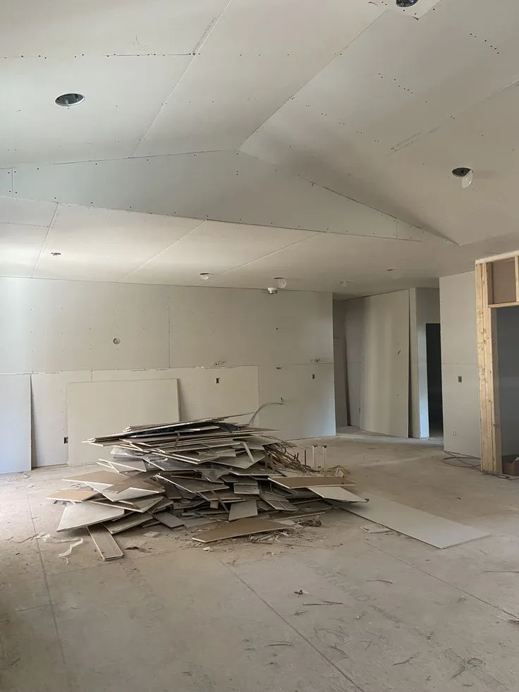 "أعمال تركيب أسقف وجدران الجبس بورد في مرحلة التشطيب، مع وجود مخلفات البناء في الموقع، ضمن مشروع ترميم بالدمام."