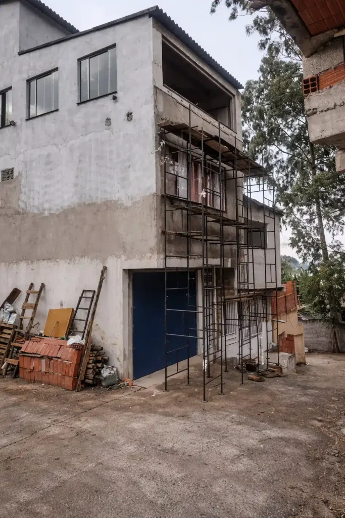 منزل من عدة طوابق أثناء تنفيذ أعمال ترميم الواجهة الخارجية مع تركيب سقالات حديدية وتجهيز الجدران قبل الترميم