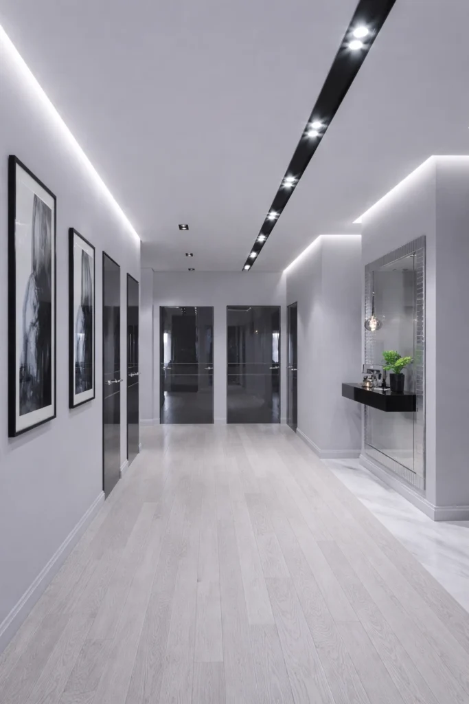 دهان ممر داخلي بألوان رمادية فاتحة مع إضاءة مخفية وتصميم عصري للأبواب والجدران