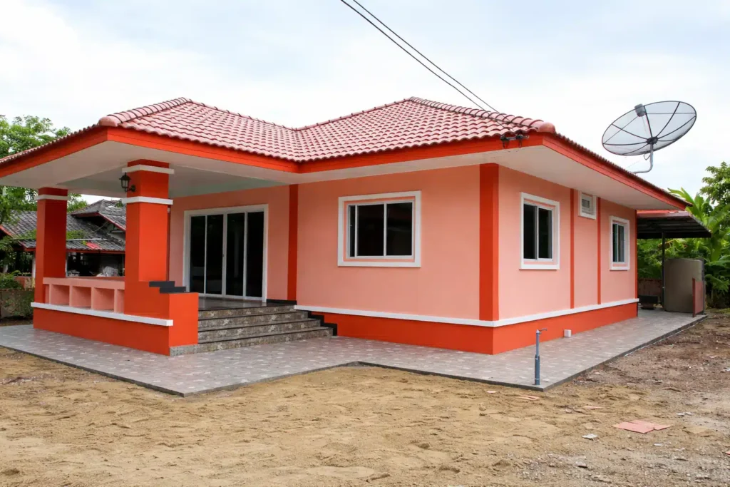 ملحق أرضي بتصميم عصري بلون خوخي مع لمسات برتقالية وسقف قرميد أحمر ومدخل بدرج أمامي