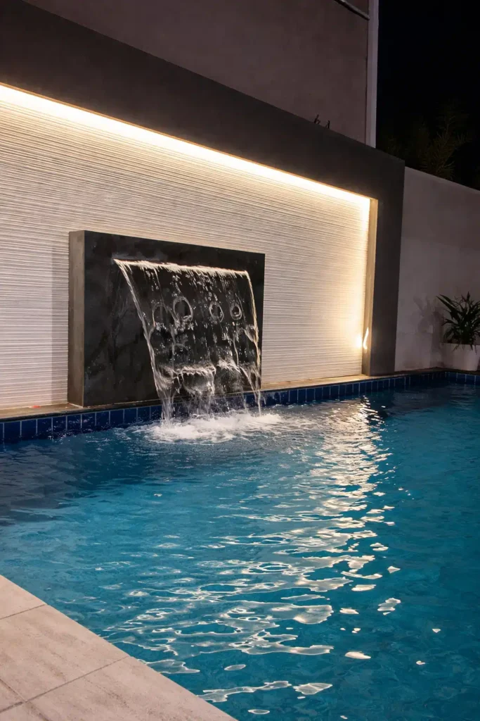 مسبح خارجي بتصميم فاخر مزود بشلال جداري حديث، مع خلفية جدارية بإضاءة مخفية