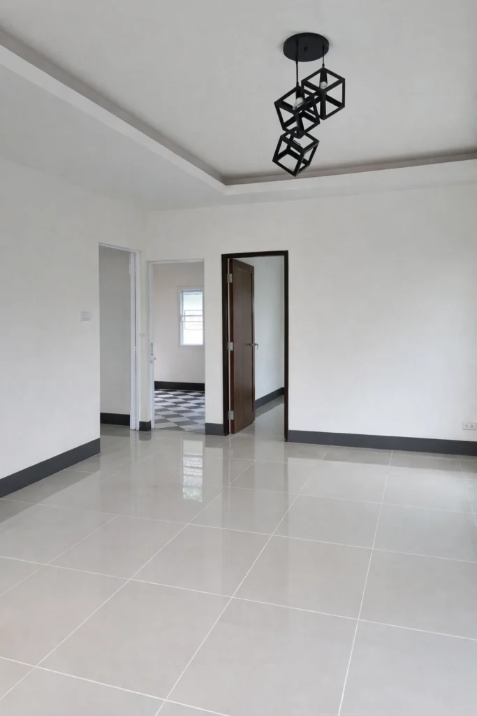 غرفة داخلية بطلاء أبيض هادئ وجدران ناعمة مع سقف جبس بسيط وحواف ديكورية، وأرضية سيراميك لامعة تعكس الإضاءة