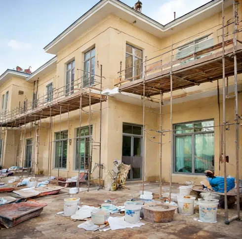 أعمال ترميم الواجهات الخارجية للمبنى مع تركيب سقالات وتجهيز الجدران قبل مرحلة الدهان والتشطيب