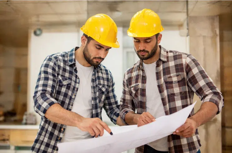 فريق مقاول ترميم يراجع مخطط أعمال التجديد داخل موقع العمل قبل بدء تنفيذ المشروع